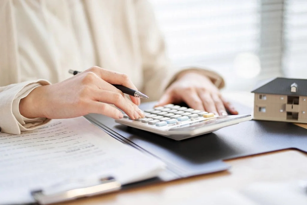 The hands of an accountant typing on a calculator.