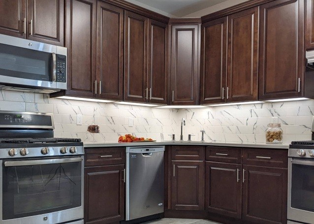 Modern kitchen with dark wood cabinets and stainless steel appliances